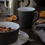 Single white Lagoa Eco Gres mug styled on dark wood surface with dried orange slices and bowl