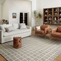 Polly Slate Ivory Rug styled in a living room with leather armchairs and shelves in warm neutral tones