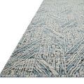 Side angle view showing the thick textured pile and sturdy handwoven edges of the Raven Blue / Ivory Rug