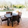 Laguna Dining Chairs styled around dark outdoor dining table on sunny patio