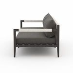 Sherwood sofa left side profile emphasizing texture of neutral woven straps and plush charcoal cushions.