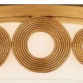 Detailed macro of large concentric circular brass elements on light frame
