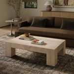 Abaso coffee table styled in living room with brown sofa, side table, and decorative rug