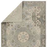 Back side of rug folded to display hand-knotted construction and muted color palette