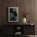 Secondary view of artwork installed above modern black console with decor on a vertical wood slat wall