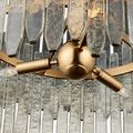 Close-up of warm antique brass center sphere with three attached light sockets surrounded by glass bars