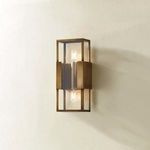 Santa Clara wall sconce angled on beige wall with warm light softly illuminating surroundings