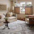 Hollis Mist rug styled in living room with beige sofa, armchair, and natural light