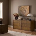 Styled dresser in room setting with artwork, lamp, and decorative items on top