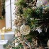 close-up of mosaic glass ornament hanging on green Christmas tree with gold and silver decorations