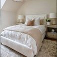 Bedroom with Blake duvet layered with neutral beige throw blanket and pillows on cream upholstered bed