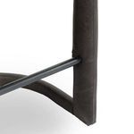 Tight focus on black metal footrest attached to padded leather frame with clean stitching