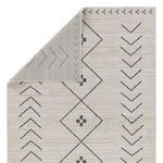 Back side of rug folded to show dual-sided woven pattern and edge binding