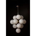 White swirl glass chandelier glowing warmly against black background