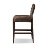 Side profile of Jayla counter stool showing padded backrest curve and wood frame details