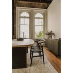 Side view of two Ventana dining chairs styled at edge of wooden table in bright loft dining area