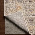 Rug corner flipped over to reveal the non-slip backing on a dark hardwood floor.