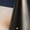 Close-up of the lamp’s conical base showing integrated touch control button and matte finish texture
