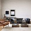Side view of industrial loft space with two large framed abstract paintings hung over leather armchairs