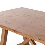 Top surface close-up showing wide pine planks and knots on Trellis dining table's warm wood finish