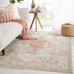 Modern living room styling featuring the rug with a wood tripod side table and plush cushions
