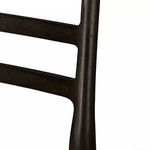 Close-up of chair corner showing seat fabric wrapping and carbon wood frame near rear leg