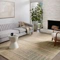 Bright living room with Bowery Beige Multi Rug beneath grey sofa and white side chair near fireplace