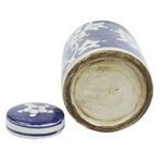 Close-up view of the jar's base showing aged ceramic and detached lid next to it