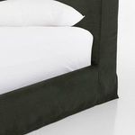 Tight close-up of dark green linen fabric with visible natural weave texture