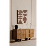 Polished nickel candle holders styled with lit candles on a wooden sideboard under a framed abstract wall art