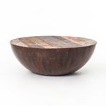 Side angle of coffee table showing curve of half-sphere base and wood plank top from a slight elevation