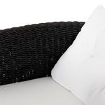 Close-up of white tufted back cushion against black woven chair frame