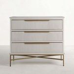 Distressed antique white wood chest with three ribbed drawer fronts and satin brass base in cross design