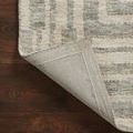 Edge of rug folded back exposing backing fabric and detailed finishing stitching