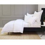 Side angle showing duvet set's full bedding arrangement with grey paneled wall backdrop and black bed frame