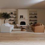 Wide living room shot showing table positioned between white and brown upholstered sofas