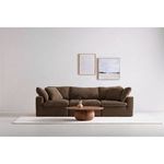 Front-facing angle with dark brown sofa on white rug and abstract wall art behind, table centered in shot