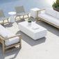 Coastal Teak Sofa in outdoor patio setting with matching chairs and white cushions