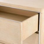 Partially open top drawer showing smooth interior wood finish and metal trim around drawer front