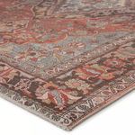 Close-up of rug corner showing detailed woven floral border and flat texture