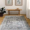 Margaret Blue/Gray rug displayed flat on hardwood floor in minimalist room with bench, plant, and framed artwork