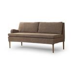 Three-quarter angle showing single armrest and tapered oak legs of banquette