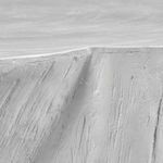 Macro detail of matte white coffee table showing deep grooves and natural crack in the surface