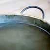 Close-up detailing inside galvanized tray showing textured surface and brass-rimmed handle