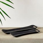 Trays displayed on stone surface near green leaves, showcasing matte finish