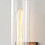 Close-up view of lit filament bulb inside clear cylindrical glass shade