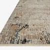 Leigh Ivory Granite Rug with abstract distressed pattern in beige, ivory, black, blue, and gold tones from a low angled co...