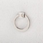 Close-up of silver metallic ring pull handle mounted on textured grasscloth door