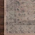Edge detail of Hathaway Blush / Multi Rug showing hand-stitched beige zigzag border on wooden hardwood floor.