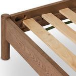 Back corner close-up of bed showing simple wood panel and smoked oak leg